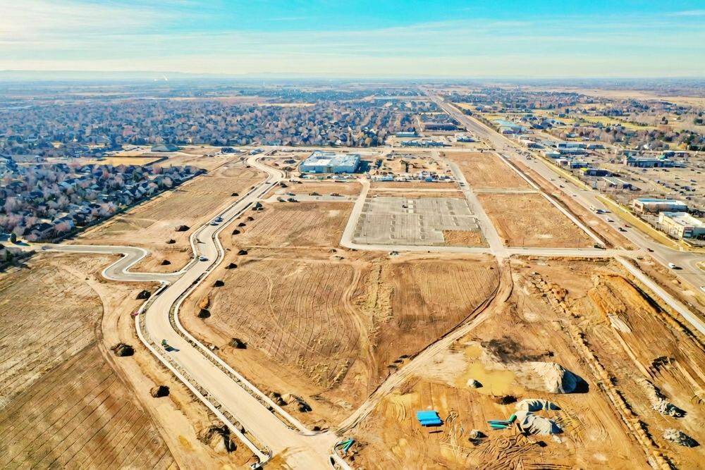 Aerial view of a subdivision under construction with new roads and graded lots